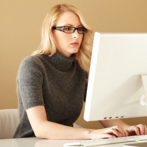 Attractive young woman typing on her computer